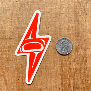 red alaska native lightning bolt vinyl sticker next to a quarter