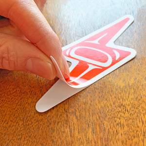 closeup of tlingit lightning bolt laptop vinyl sticker being peeled